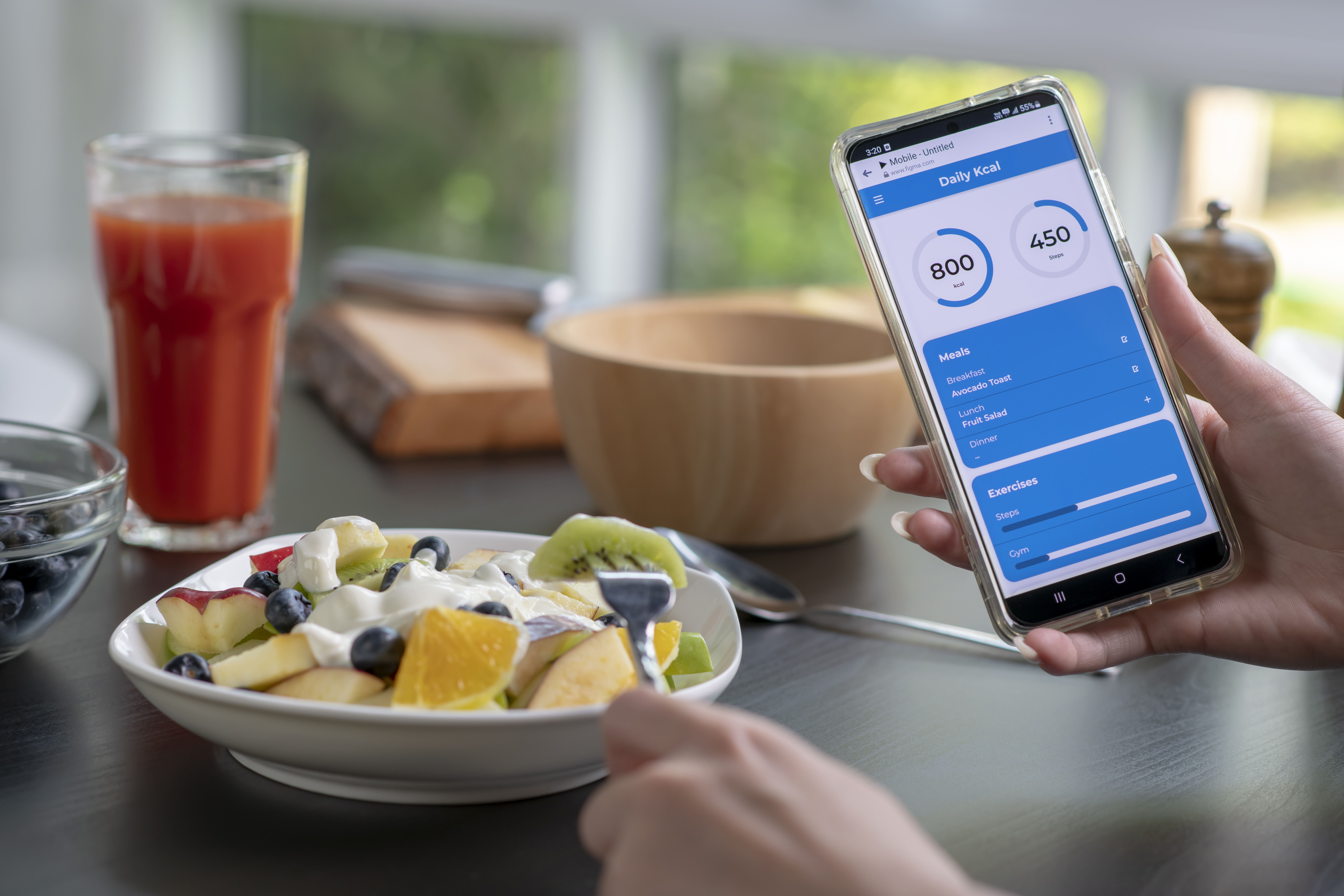 Woman checking calories and nutrients app on her phone while having a meal. Professional Nutritionist.
